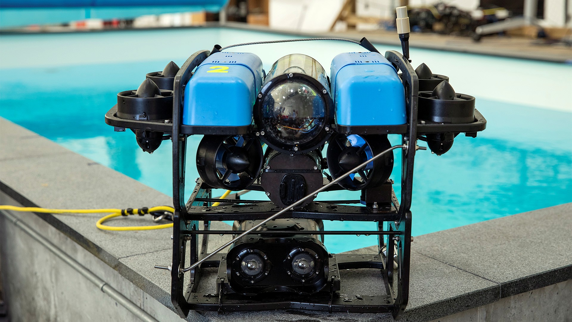 A surveillance submarine sitting on the edge of a testing pool.