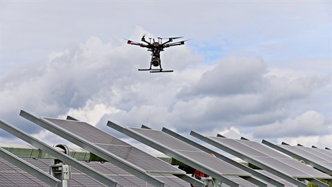 Drone flying over solar panels monitoring for cracks and shade