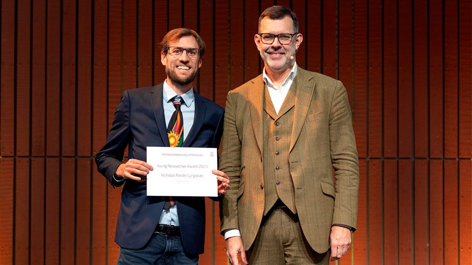 PhD Nicholas Riedel-Lyngskær photographed alongside provost Rasmus Larsen, holding his diploma for the Young Researcher Award 2023