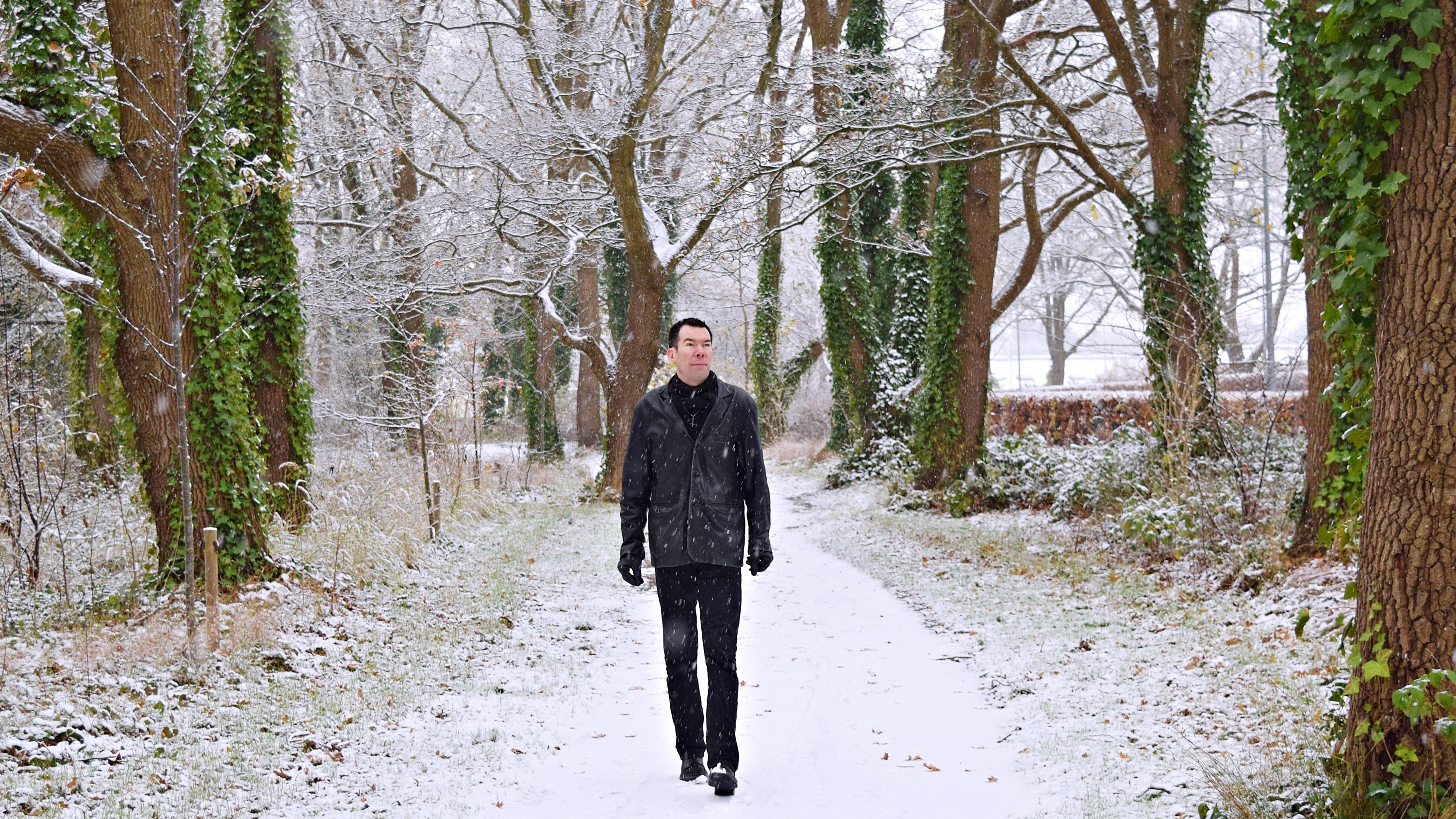 Professor Niels Gregersen walking in the snow between trees